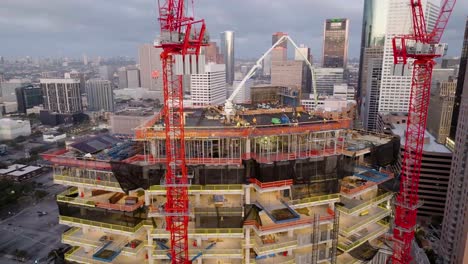 Disparo-De-Drones-Inclinándose-Frente-A-Un-Edificio-Alto-En-Construcción,-En-Houston,-EE.UU.