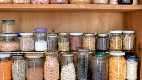 jars of spices and cereals in kitchen cupboard, pull back reveal