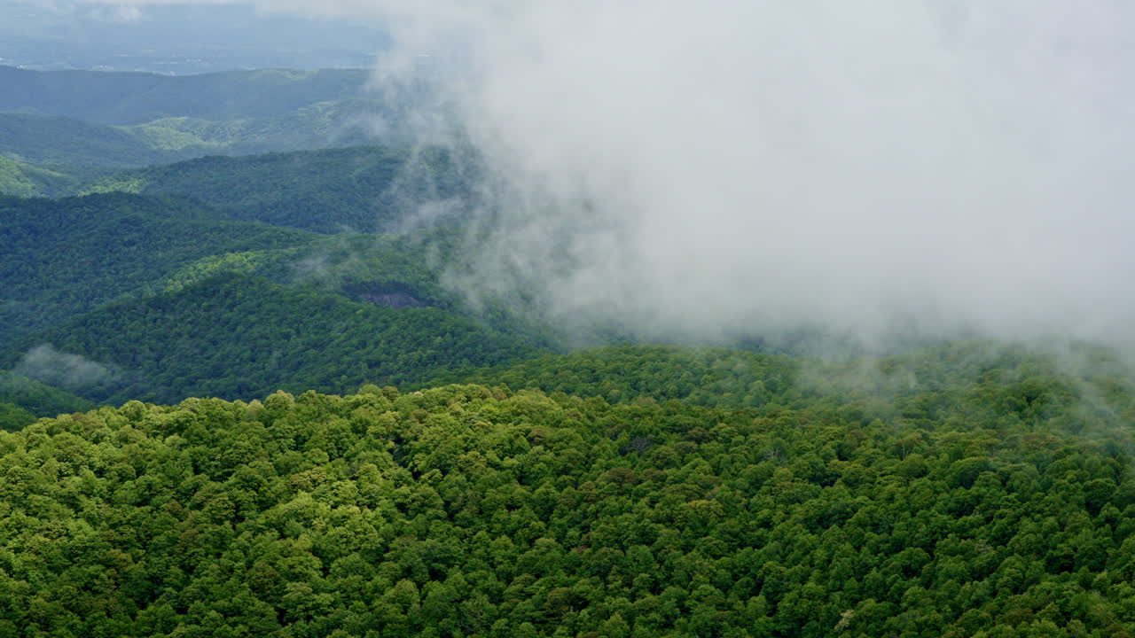 Rainy drone flight over a blanket of fog rolling through the Smoky peaks