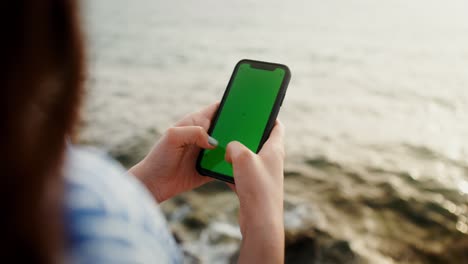 mujer usando el teléfono en la playa