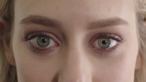 mujer joven ojos azules abriéndose con maquillaje belleza femenina macro de cerca