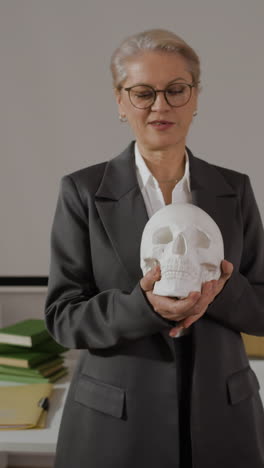 woman holding a skull in a classroom