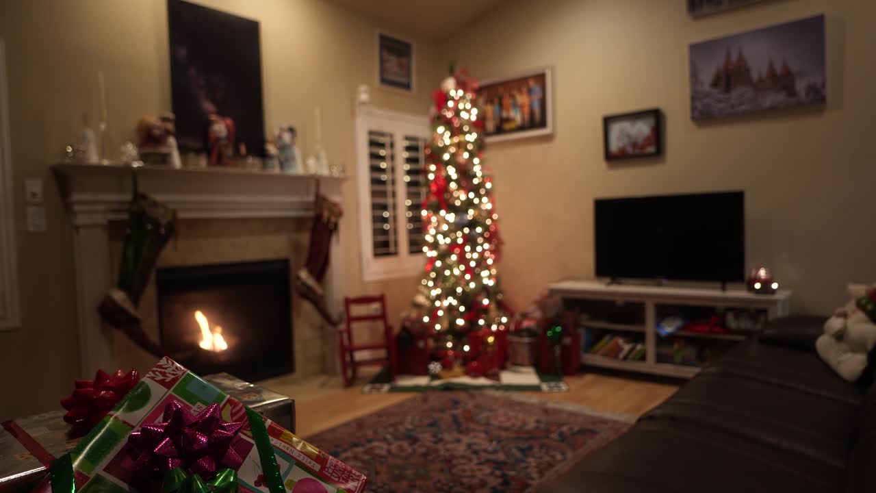 árbol de navidad en una habitación acogedora junto a la chimenea con regalos en primer plano - vista estática