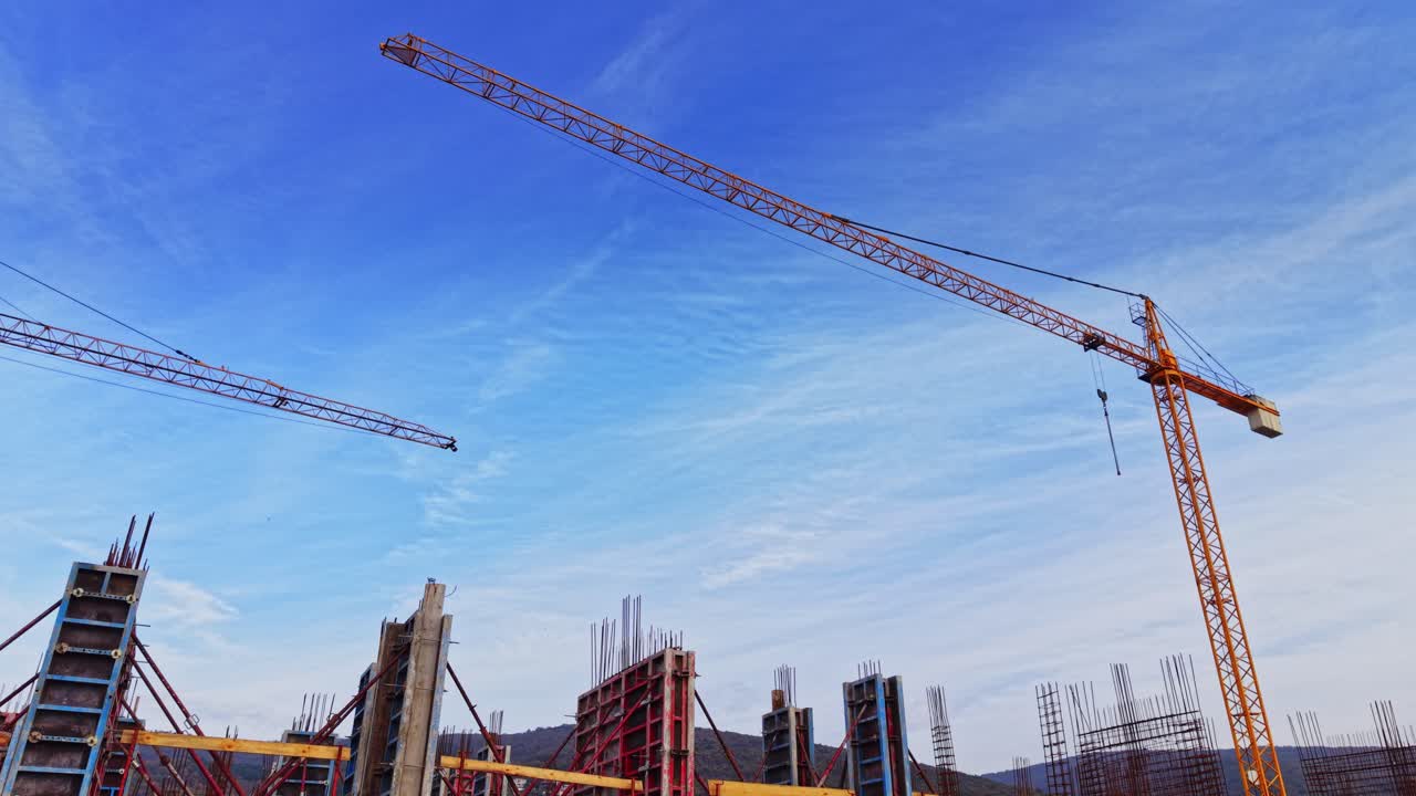 Construction site with cranes and rising structures under blue sky
