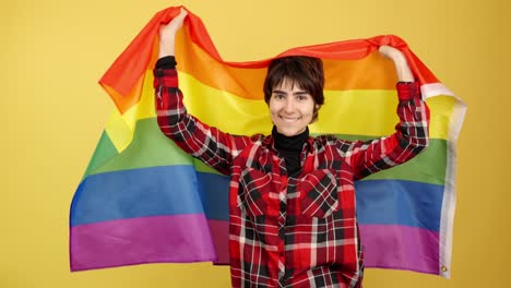 smiling person holding a rainbow pride flag