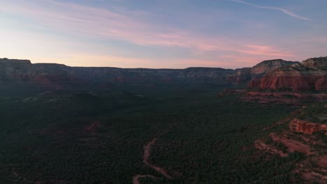 Llanuras-Con-Arbustos-En-Crecimiento-Y-Montañas-De-Roca-Roja-En-Sedona,-Arizona-Al-Atardecer---Toma-Aérea-De-Drones