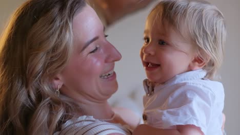 woman holding smiling baby sharing heartwarming moment a heartwarming video shows a woman holding a baby both smiling and sharing a loving moment they look at each other demonstrating a strong bond filled with love and affection