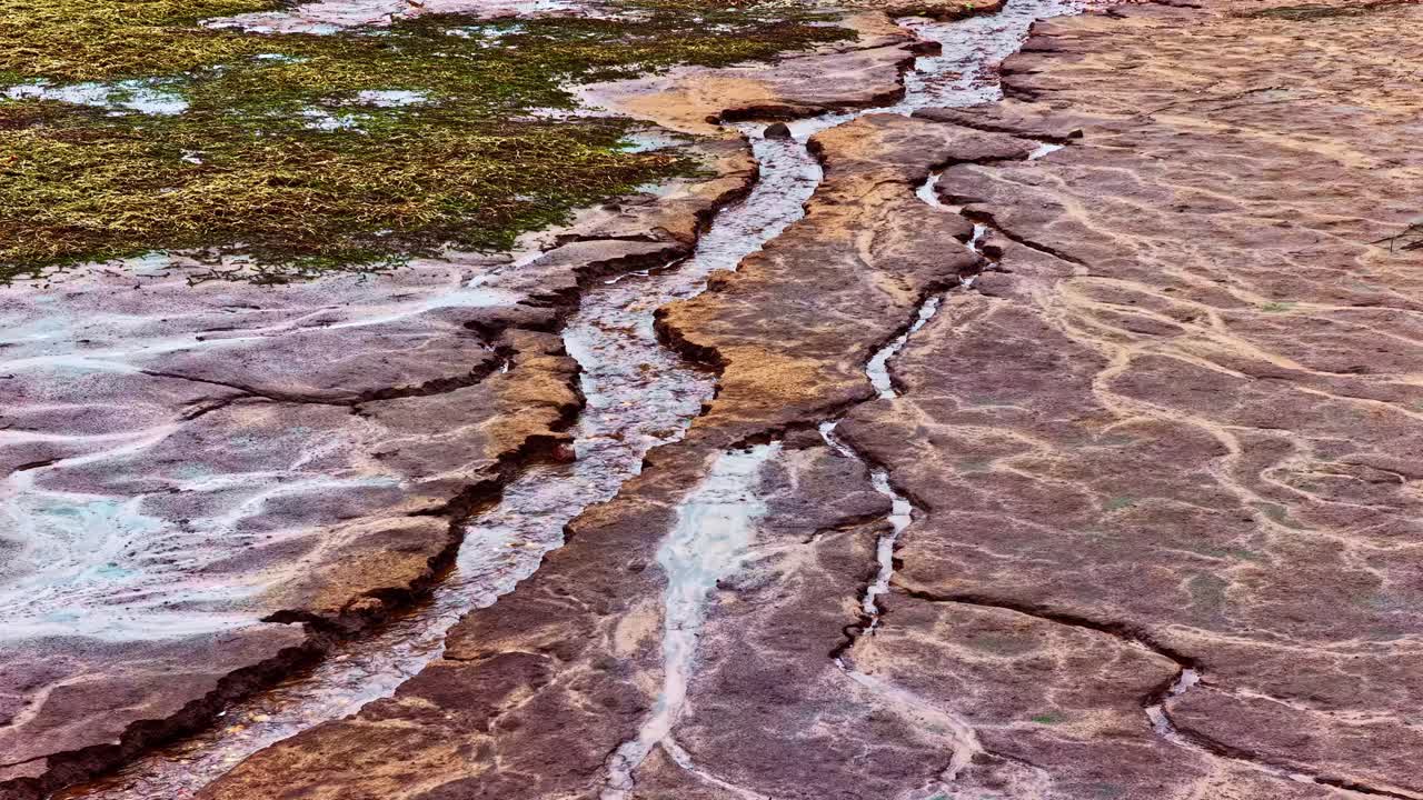 Cracked mud and sediment layers with drying riverbeds and erosion patterns, natural drought backdrop