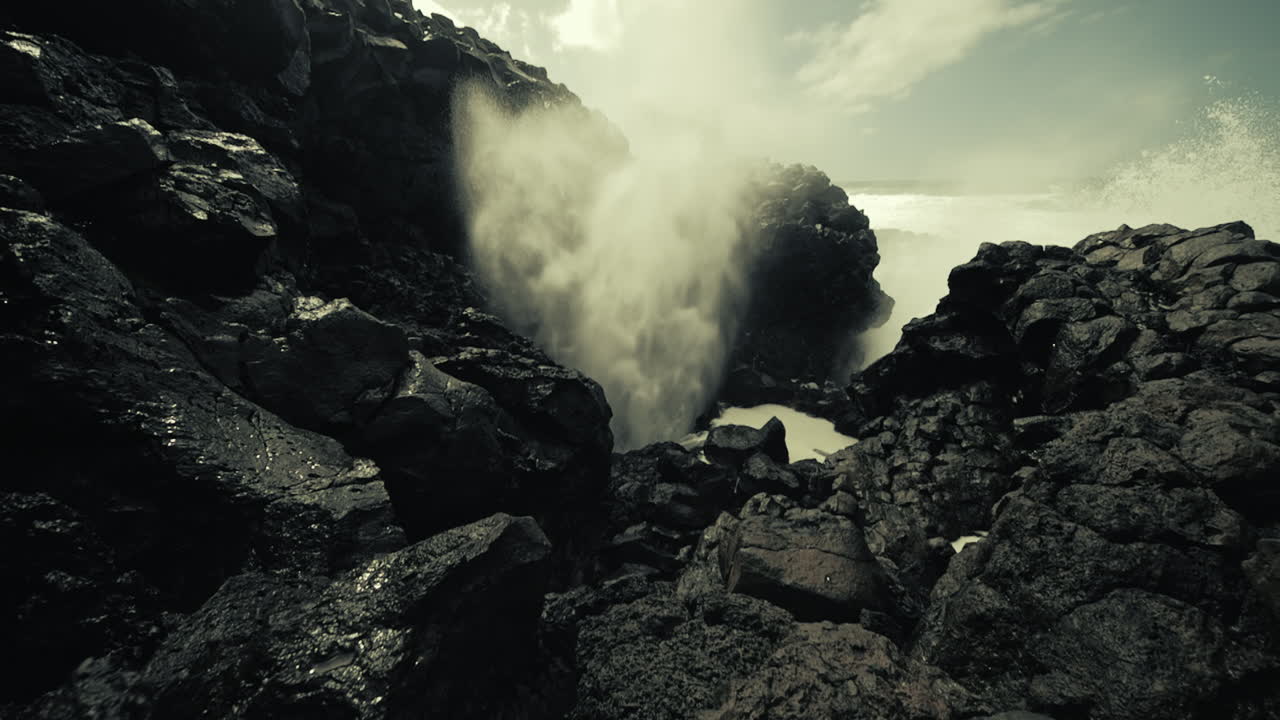 Powerful Waves Crashing Through Volcanic Rocks