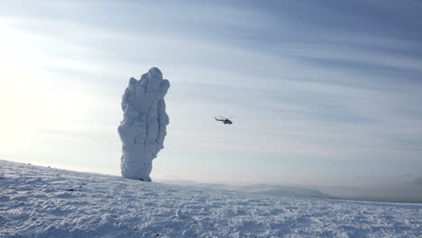 paisaje montañoso nevado con helicóptero