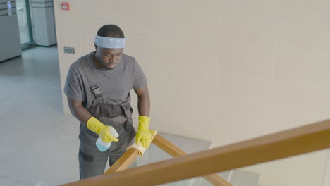 Draufsicht-Des-Reinigungsmanns,-Der-Treppengeländer-In-Einem-Bürogebäude-Reinigt
