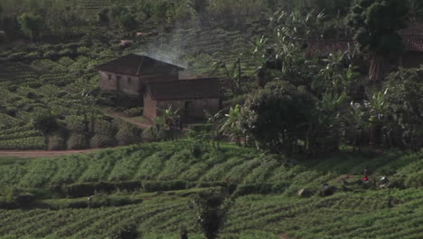 los edificios de la granja se sientan en los campos de las zonas rurales de ruanda