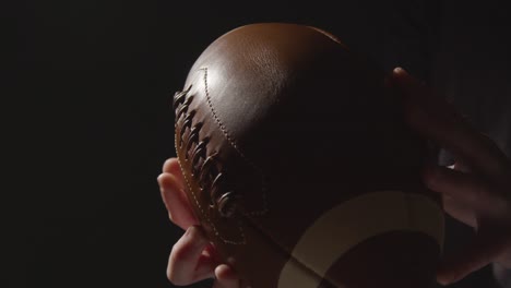 Close-Up-Studio-Shot-Of-American-Football-Player-Holding-Ball-With-Low-Key-Lighting-4