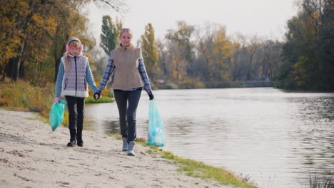 Frau-Freiwillige-Mit-Kind-Spaziergang-Am-See-Entlang-Tragen-Pakete-Mit-Müll