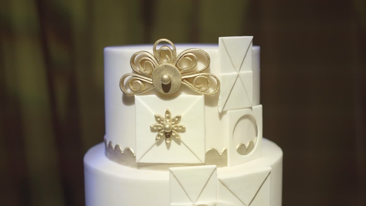 Detalhe de bolo de casamento decorativo com ornamentos clássicos.