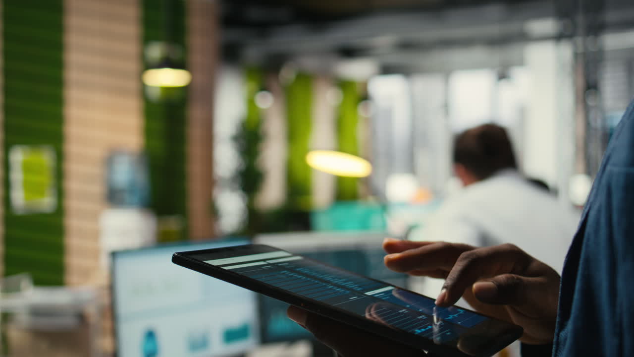 Vertical Video Close up of man reviews performance metrics insights on tablet