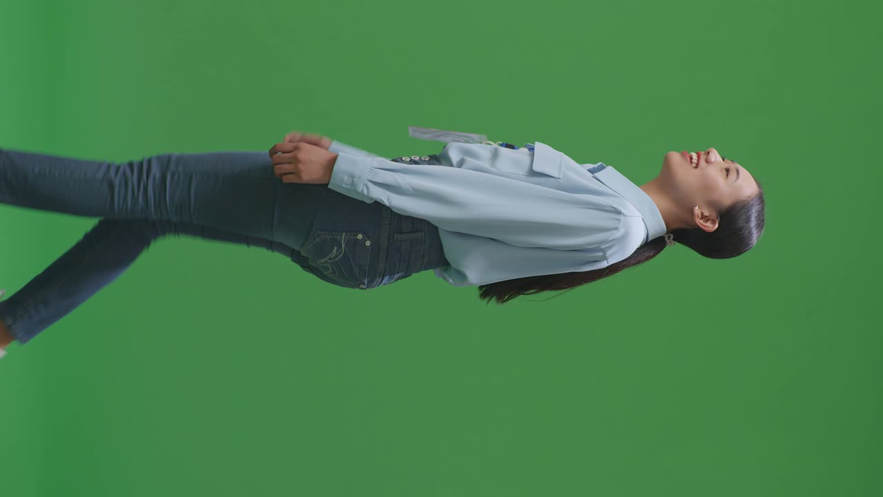 스튜디오에서 녹색 스크린 배경에서 고 있는 아시아 사업가의 측면 시각