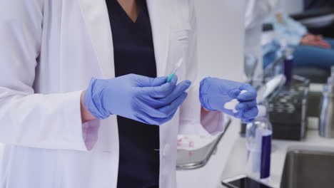 close up of beautician or doctor with syringe explaining procedure before giving botox injection