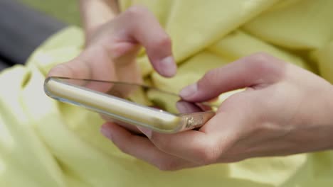 teenager boy kid alone sit on a bench use text message in smartphone closeup