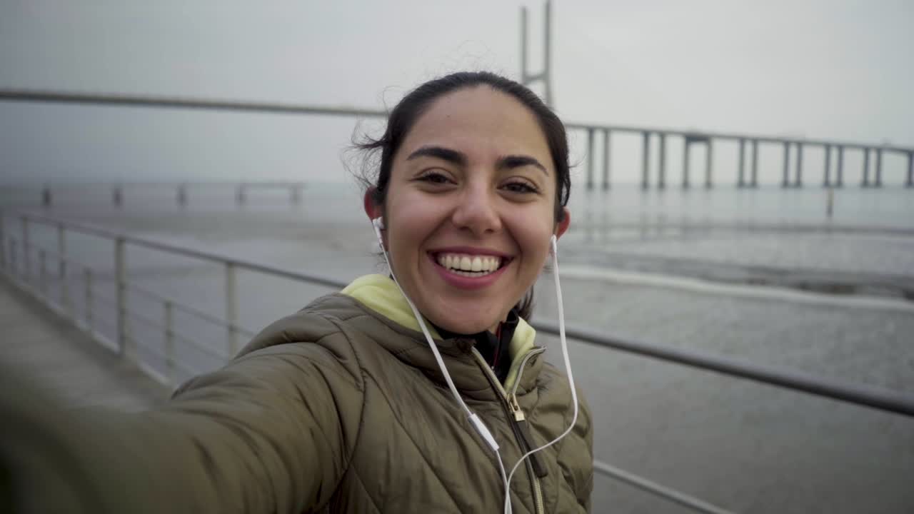 disparo en cámara lenta de una joven sonriente saludando y hablando con la cámara