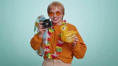 happy young woman tourist photographer taking photos on retro camera and smiling, holiday vacation