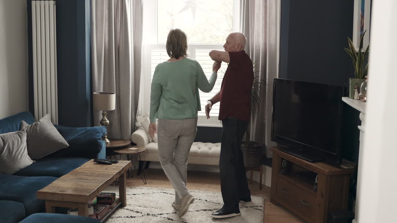 상급 부부가 거실에서 춤을 춘다.
