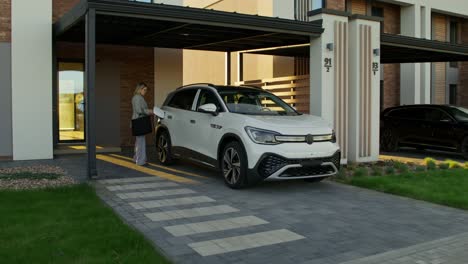 woman getting out of suv in front of modern home