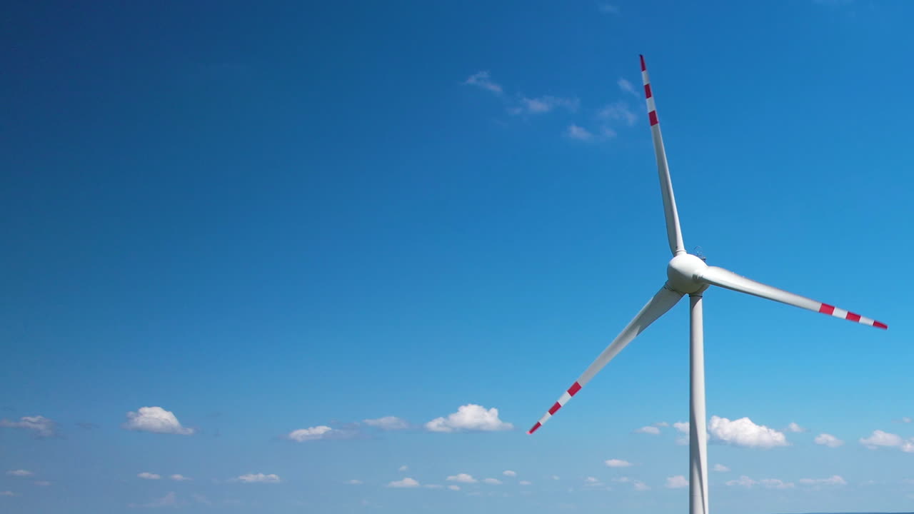 푸른 하늘을 배경으로 풍력 터빈의 회전하는 블레이드의 클로즈업 드론 뷰, 3분의 1