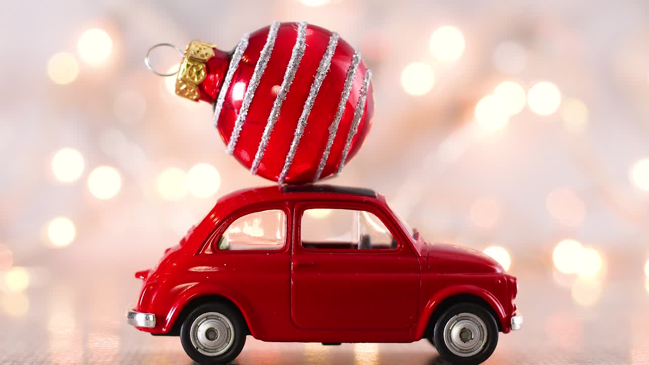 지붕에 크리스마스 빨간 장식과 뒤에 박이는 불빛이 있는 작은 빨간 차