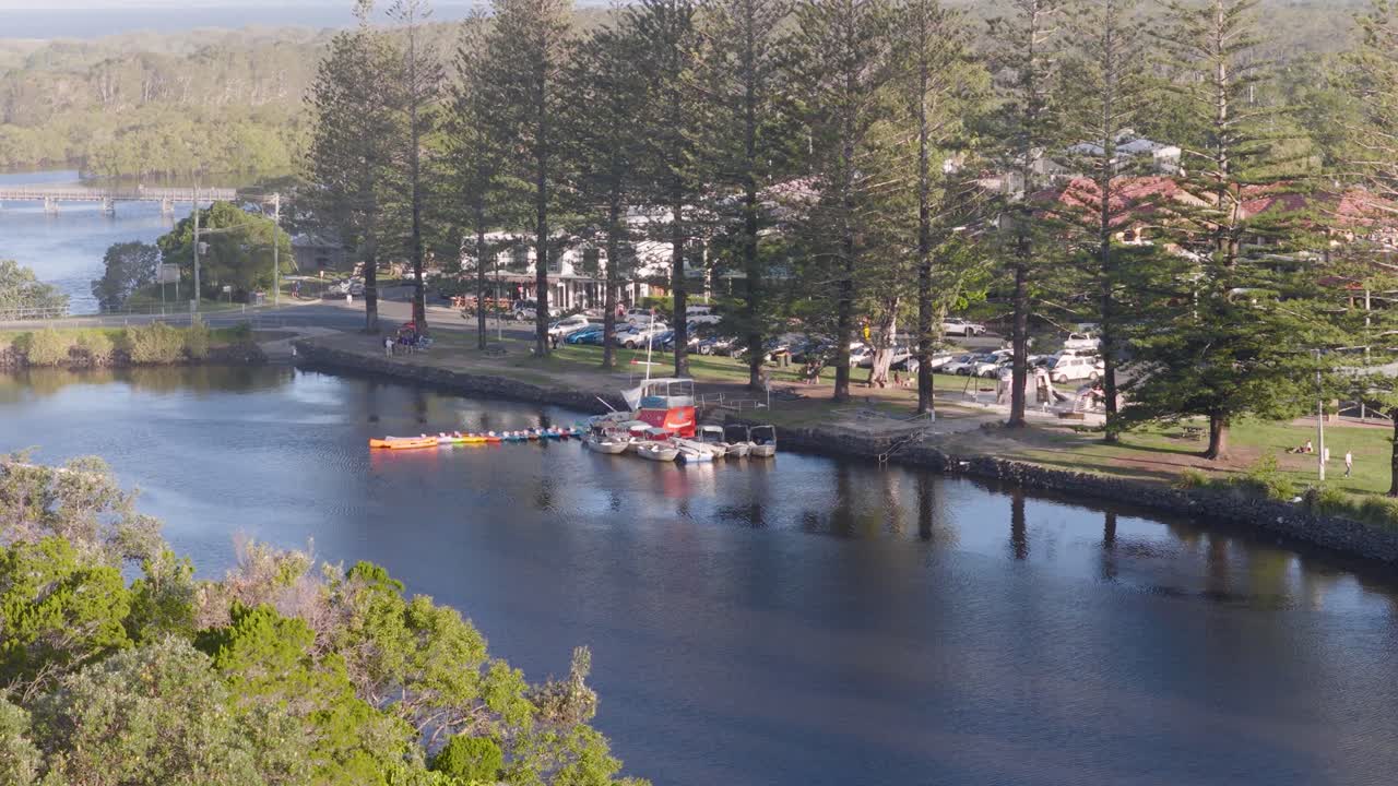 Drone captures serene river scene with yachts and boats near Brunswick Heads, NSW, under soft sunset lighting