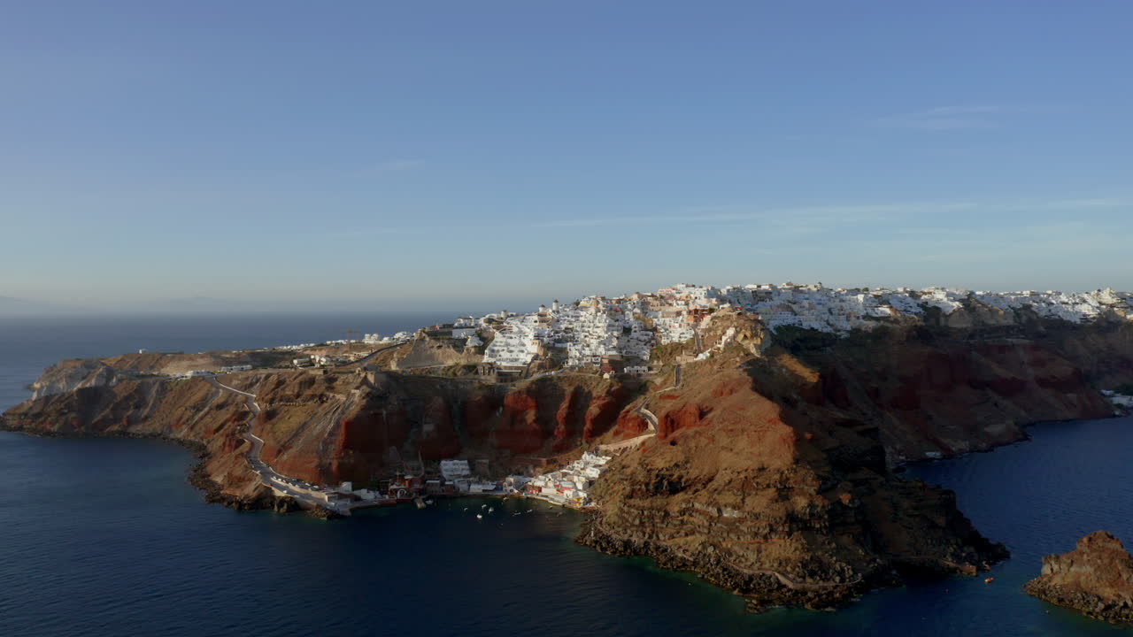 toma panorámica aérea panorámica lenta de oia en santorini, grecia durante la puesta de sol, 4k prores