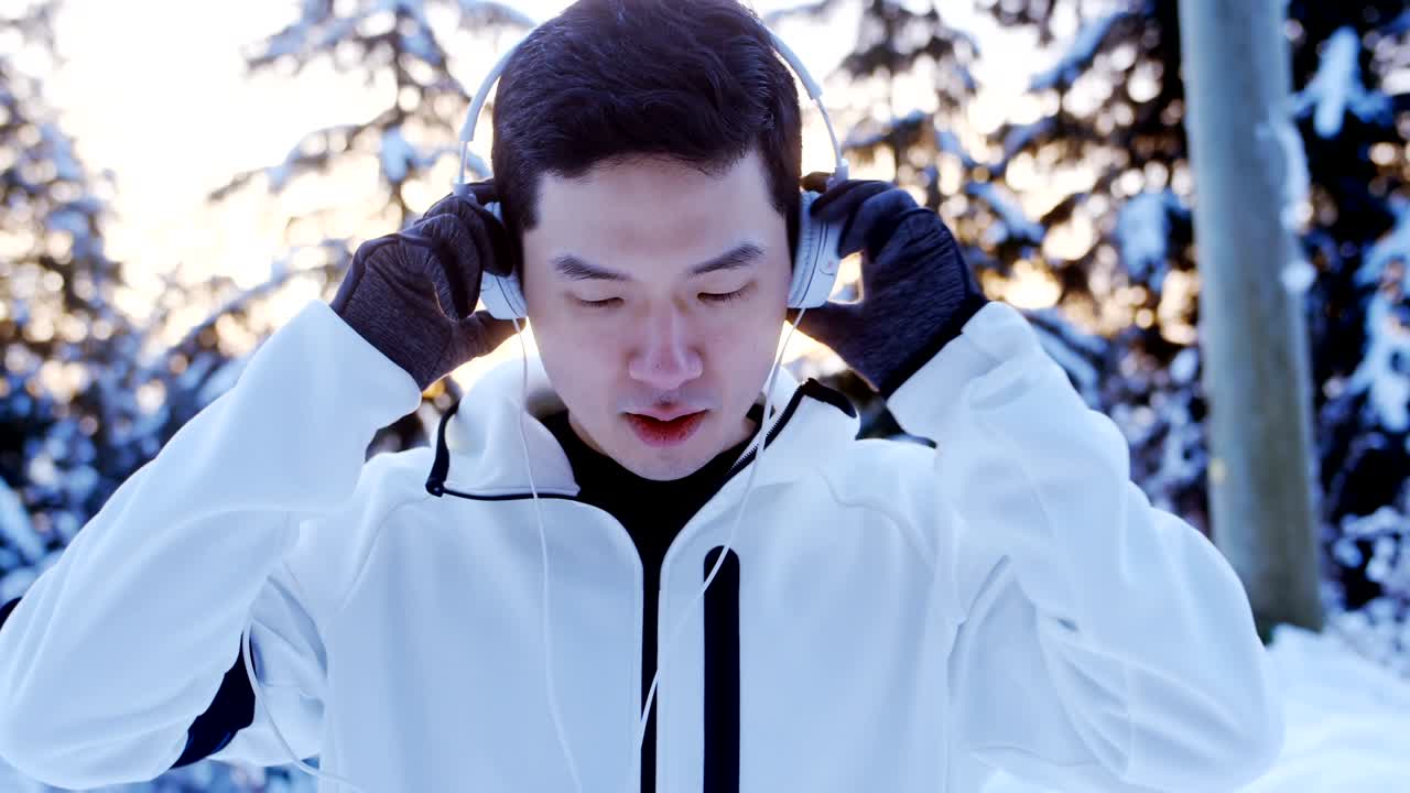 헤드폰 4k에서 음악을 들으면서 스트레칭 운동을 하는 남자