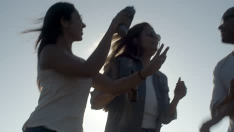 grupo de jóvenes bailando durante la puesta de sol.
