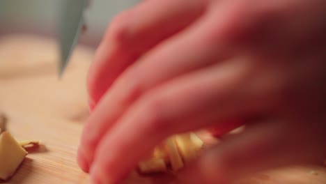mincing ginger by hand with a knife on a cutting board