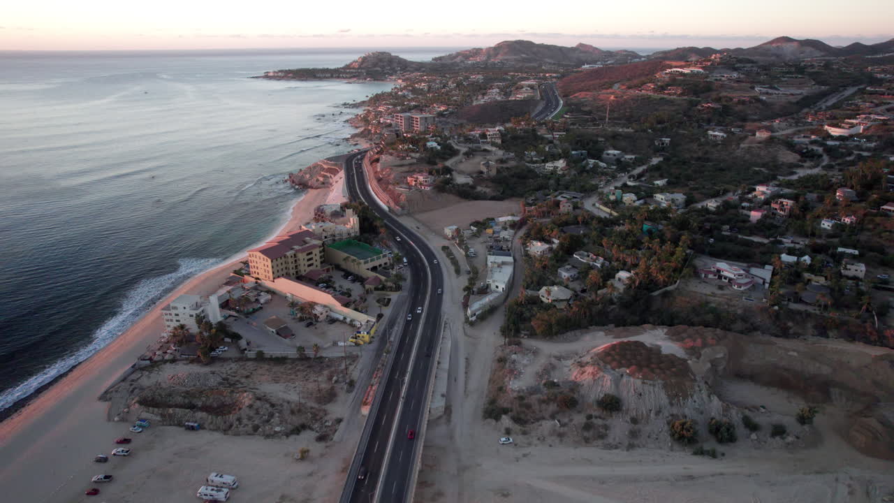 해변과 바다가 있는 멕시코 로스 카보스(los cabos) 해안을 따라 도로 위를 날고 있는 드론 뷰