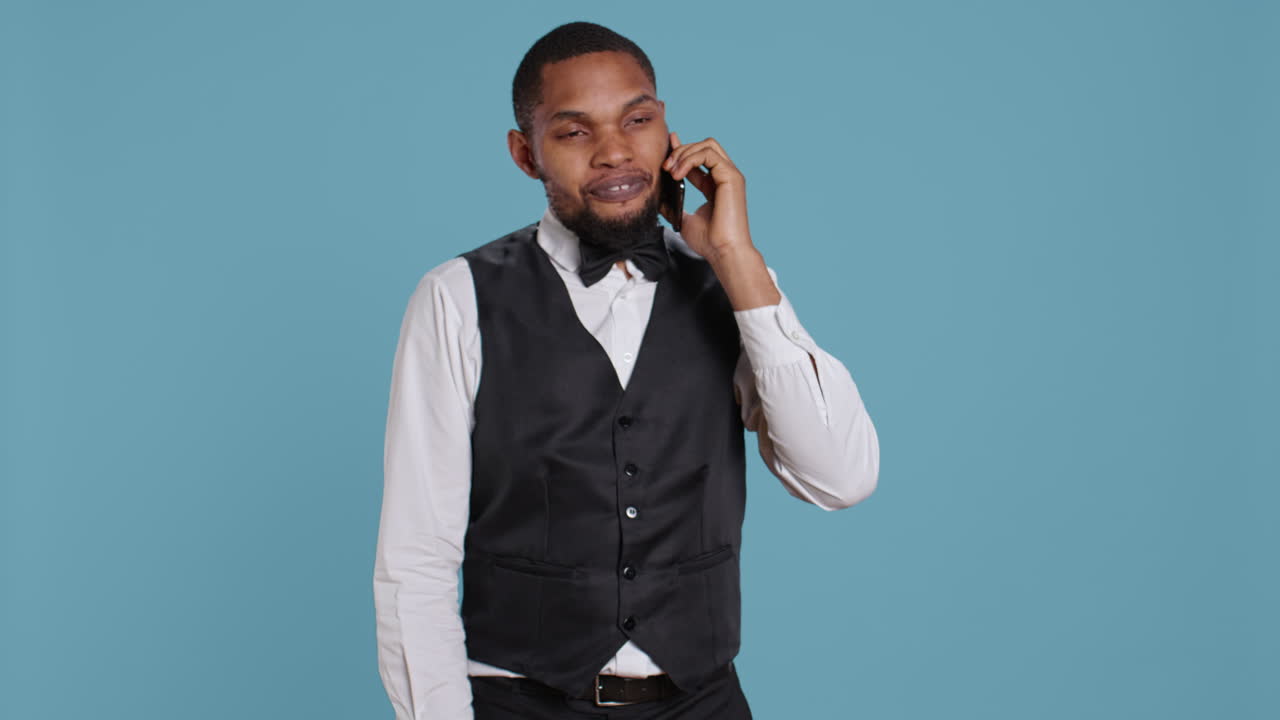 Il concierge dell'hotel in uniforme fa le prenotazioni su smartphone