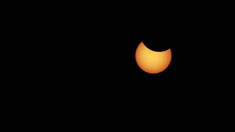 Zoom-out-of-partial-solar-eclipse-with-sunspot-visible-on-the-face-of-the-sun-and-limb-darkening-along-edge-of-sun's-disk