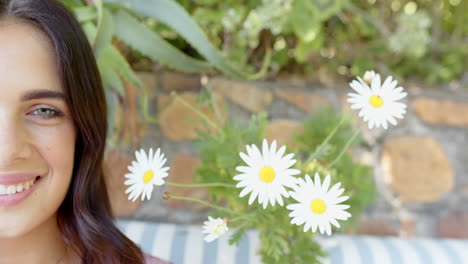 smiling woman enjoying sunny day outdoors with daisies in garden, copy space