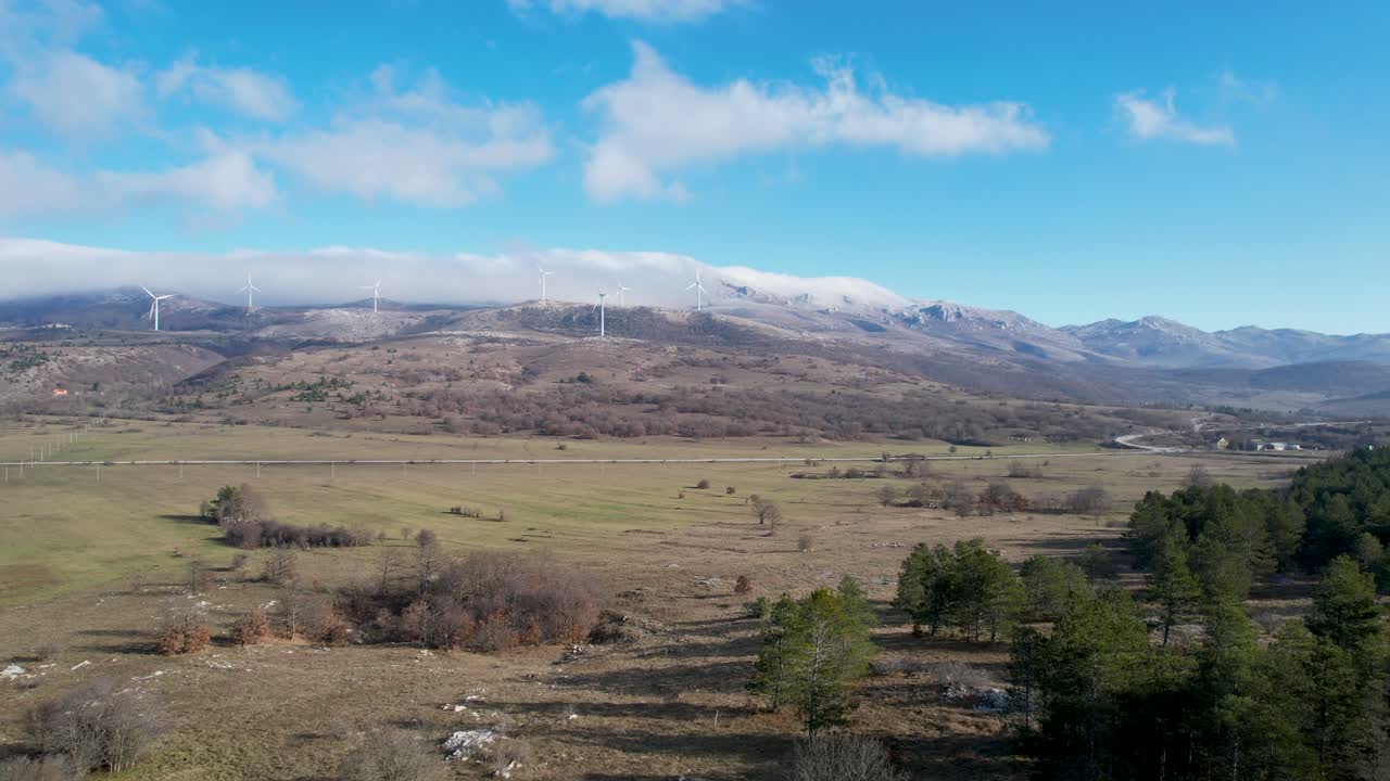 hermosa fotografía aérea del paisaje croata con turbinas eólicas que generan energía renovable en el fondo y una carretera vacía, en la región de liká en croacia, europa