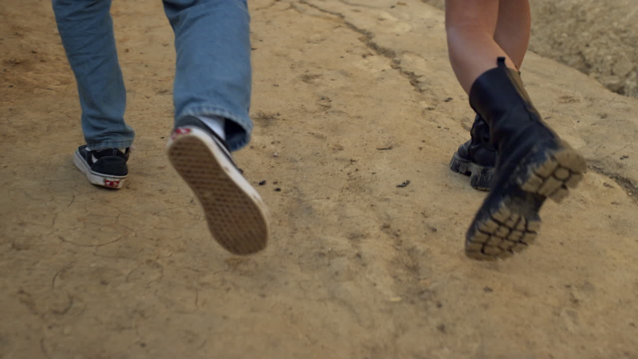 모래 해변을  ⁇ 고 있는 젊은  ⁇ 의 다리. 해변으로 가는 알려지지 않은  ⁇ 의 발