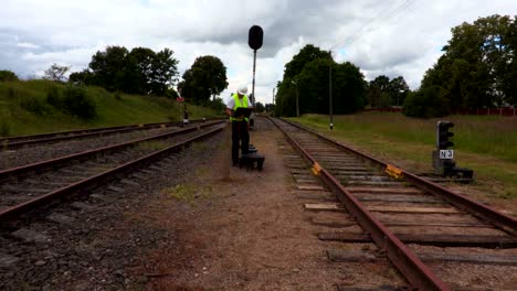 engineer using laptop on railway track