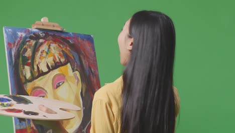 woman painting a portrait in a studio