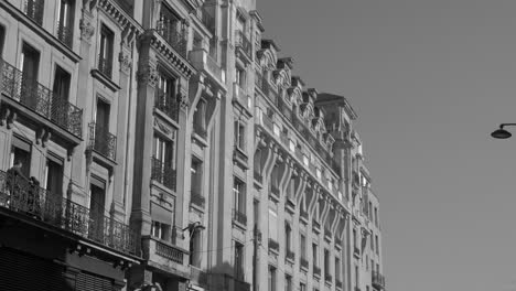 Vista-En-Escala-De-Grises-Del-Edificio-Exterior-Haussmann-Durante-El-Día-En-París,-Francia