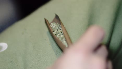 close up blunt cigar roll full of marijuana weed drug being held by male hand