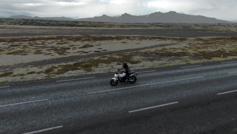 solitary motorcyclist on empty, rural road in iceland, dolly sideways