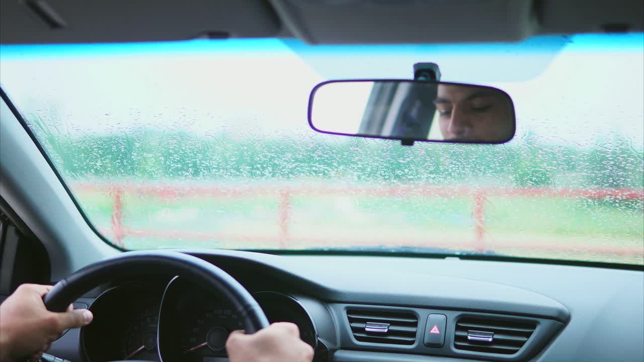 비가 오는 동안 운전하는 남자