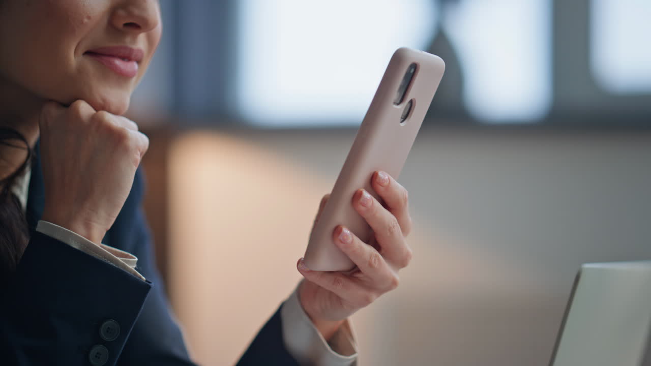 Smiling lady browsing internet online on smartphone in corporate office closeup