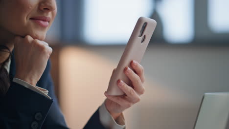 smiling lady browsing internet online on smartphone in corporate office closeup