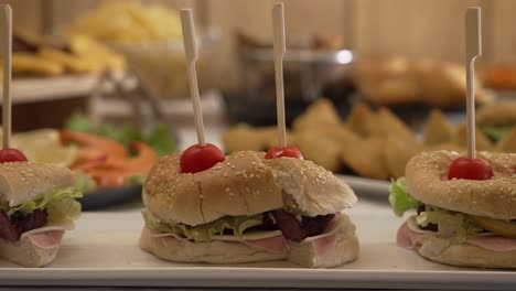tasty mini sandwiches skewered with cherry tomatoes on buffet table display