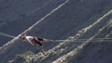 a man relaxing and laying back on a tightrope with abyss below